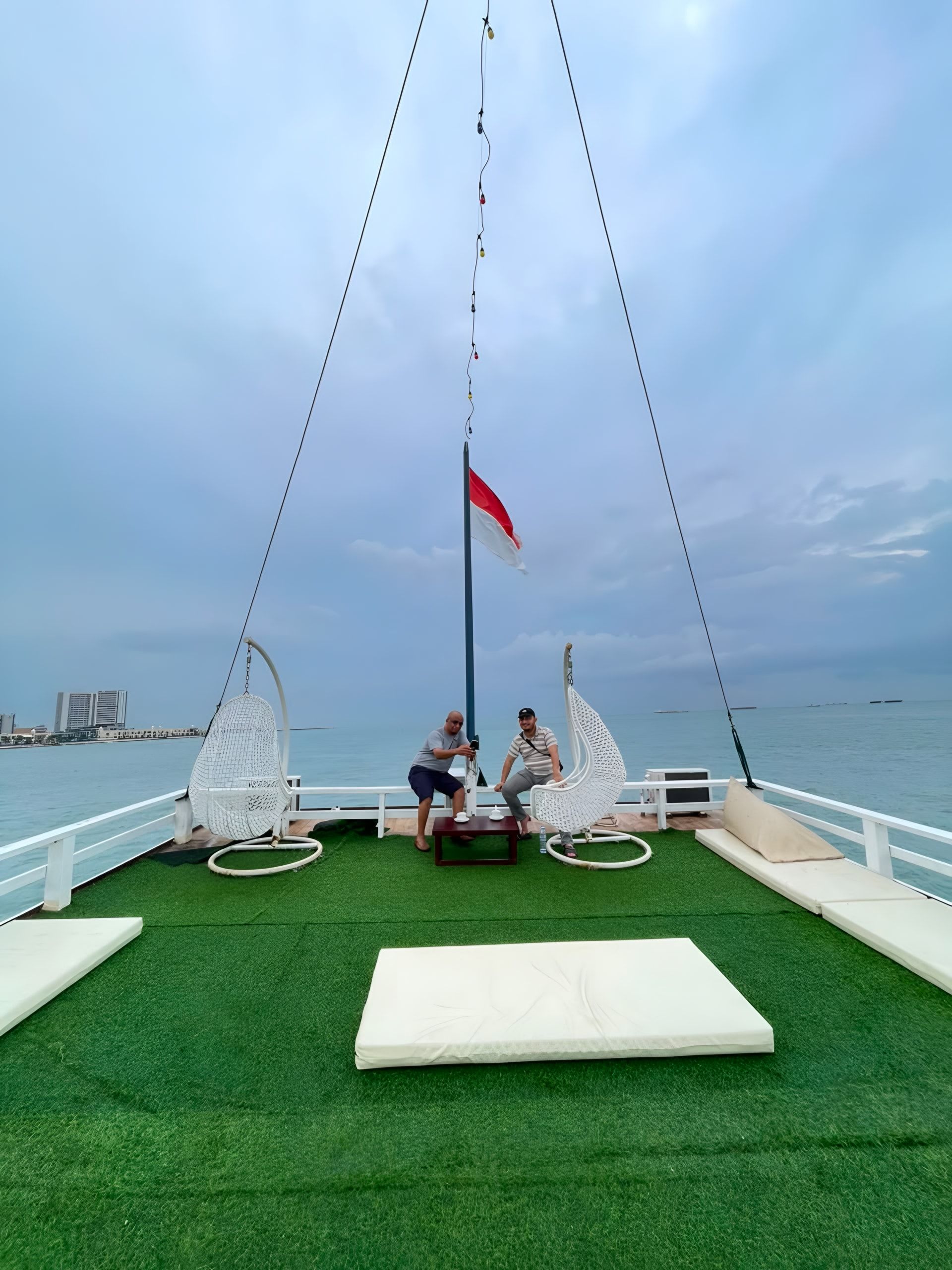 Dek atas kapal dengan kursi gantung dan matras santai